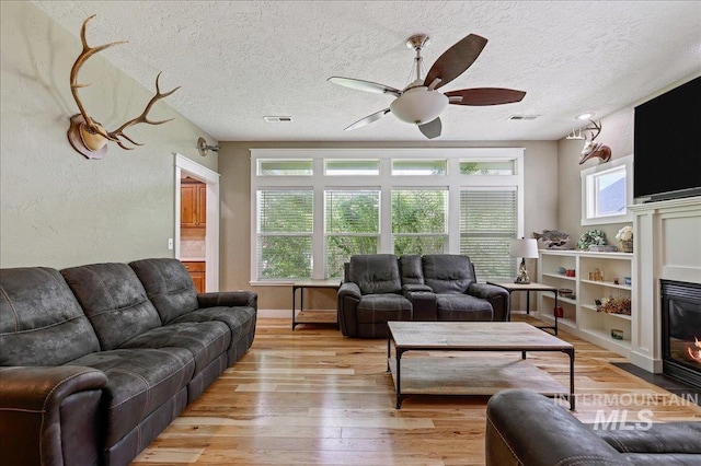 3524 Catalina Ave, Caldwell, ID 83605 - living room with ceiling fan, light wood-style floors, a textured ceiling, and a fireplace with flush hearth