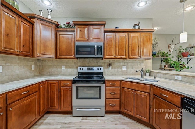 3524 Catalina Ave, Caldwell, ID 83605 - kitchen with stainless steel appliances, a sink, light countertops, a textured ceiling, and light wood-type flooring