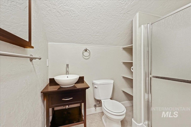3524 Catalina Ave, Caldwell, ID 83605 - full bathroom featuring a shower stall, toilet, vanity, a textured ceiling, and tile patterned flooring