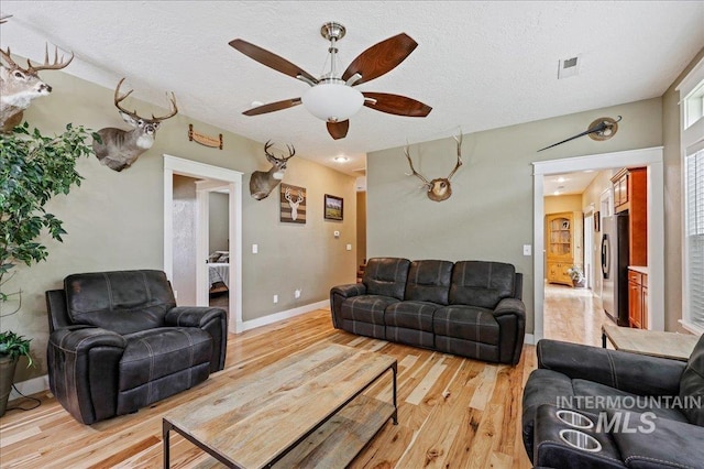 3524 Catalina Ave, Caldwell, ID 83605 - living room with light wood-type flooring, ceiling fan, baseboards, and a textured ceiling