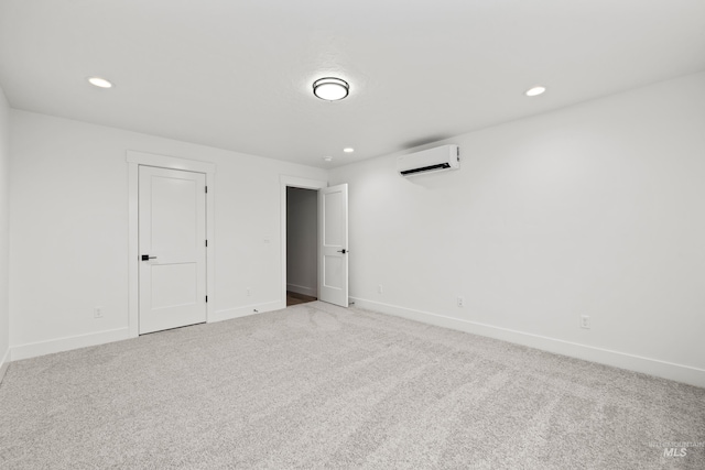 carpeted empty room featuring recessed lighting, a wall unit AC, and baseboards