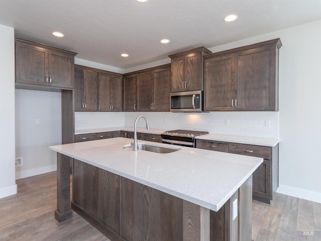 2111 W Gelding St, Middleton, ID 83644 - kitchen featuring appliances with stainless steel finishes, baseboards, a sink, dark brown cabinets, and recessed lighting