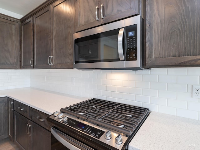 2111 W Gelding St, Middleton, ID 83644 - kitchen featuring appliances with stainless steel finishes, dark brown cabinetry, light countertops, and backsplash