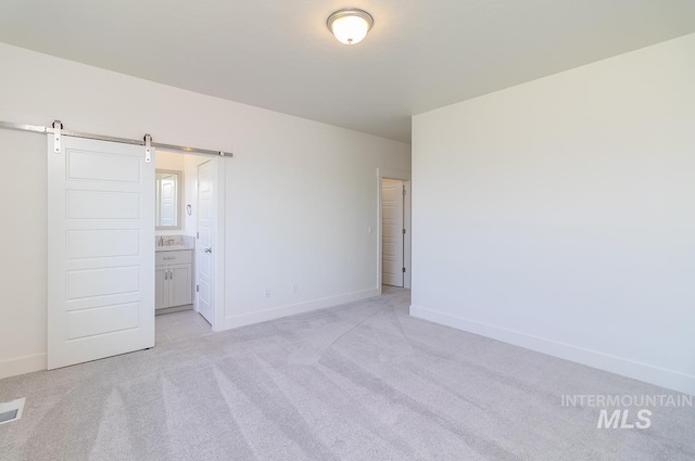 2111 W Gelding St, Middleton, ID 83644 - unfurnished bedroom with light carpet, baseboards, a barn door, and ensuite bathroom