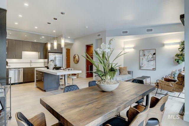 dining area featuring sink and light hardwood / wood-style floors