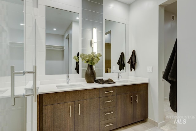 bathroom featuring tile patterned floors, vanity, and a shower with door