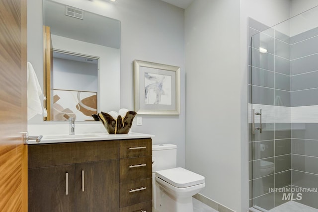 bathroom with an enclosed shower, vanity, and toilet