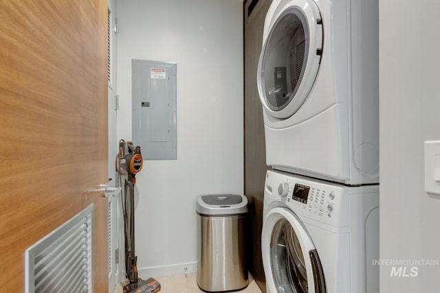 laundry room featuring stacked washer and dryer and electric panel