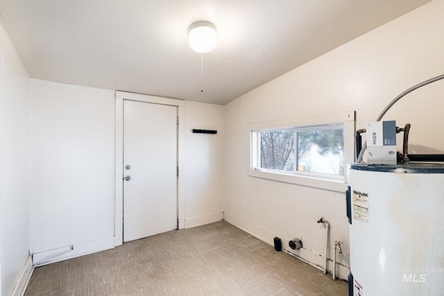 interior space with water heater, light floors, and vaulted ceiling