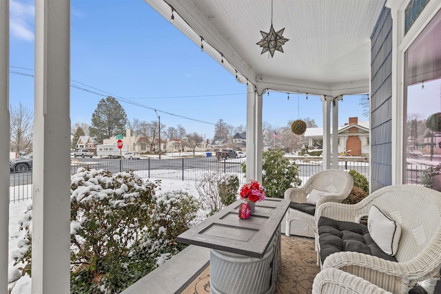 snow covered back of property with covered porch