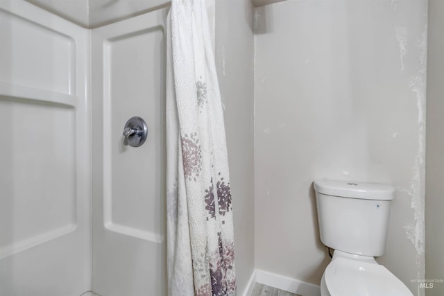 1010 E Main St, Weiser, ID 83672 - bathroom featuring toilet, a shower with shower curtain, and baseboards