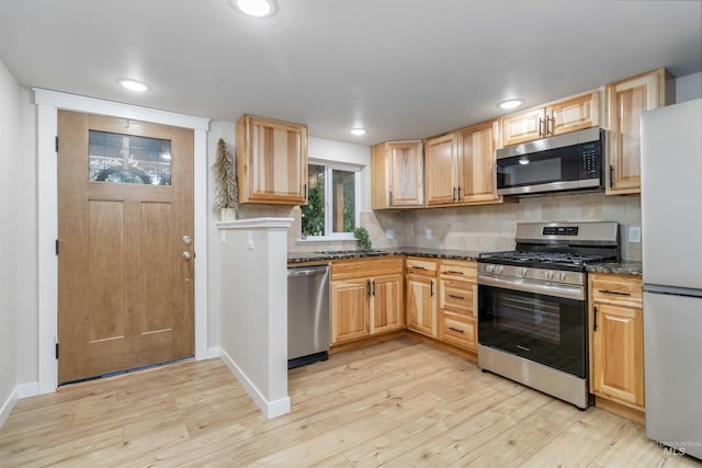1010 E Main St, Weiser, ID 83672 - kitchen featuring appliances with stainless steel finishes, light wood-type flooring, backsplash, light brown cabinetry, and baseboards