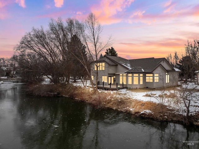 back house at dusk featuring a water view