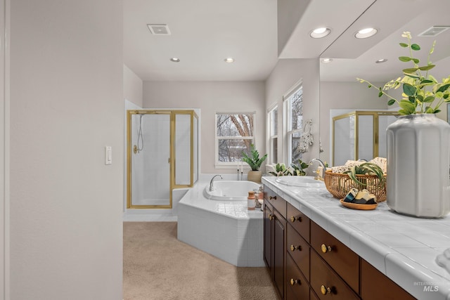 bathroom with vanity and shower with separate bathtub