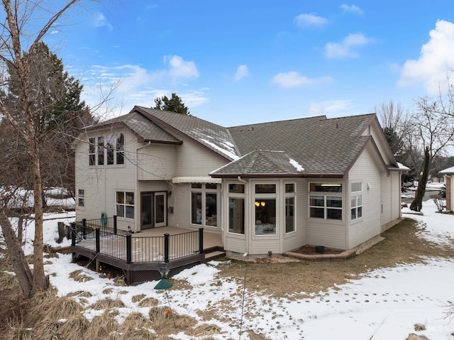 snow covered house with a wooden deck