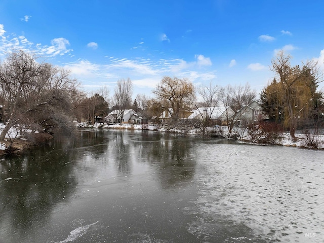 yard layered in snow with a water view