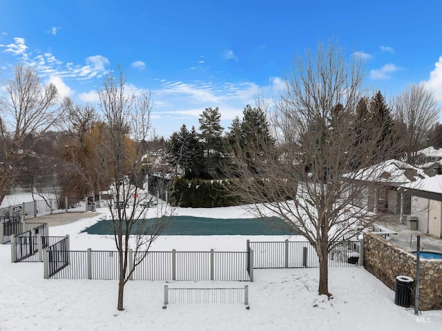 snowy yard featuring a covered pool