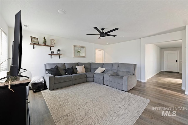 living room featuring a ceiling fan, wood finished floors, and baseboards