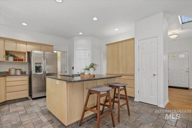 2021 W Ardell Rd, Kuna, ID 83634 - kitchen with stainless steel fridge with ice dispenser, light brown cabinets, a center island, light stone finish floors, and a kitchen bar