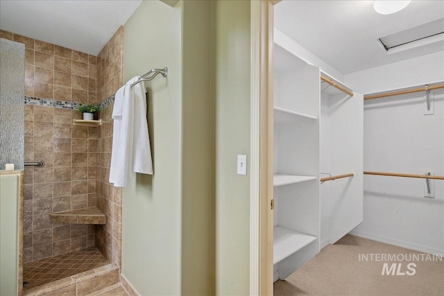 2021 W Ardell Rd, Kuna, ID 83634 - bathroom with tiled shower, a walk in closet, and baseboards