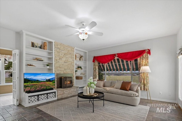 2021 W Ardell Rd, Kuna, ID 83634 - living room featuring built in shelves, a ceiling fan, baseboards, and healthy amount of natural light