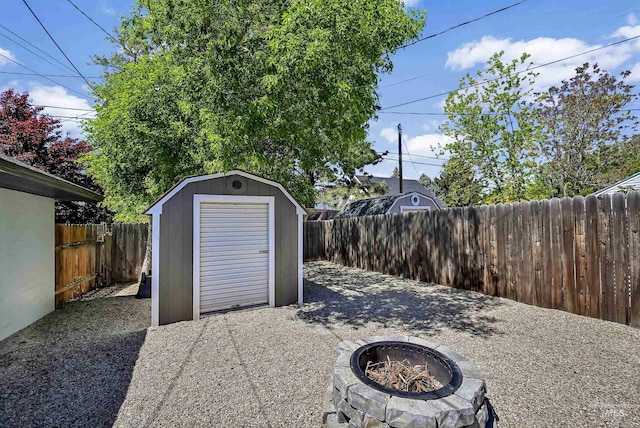 view of shed with a fire pit and a fenced backyard