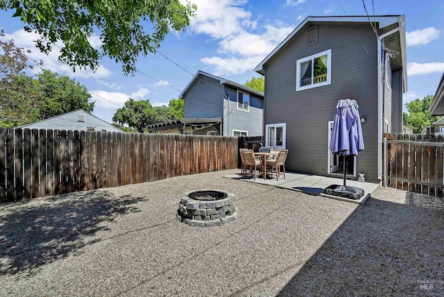 back of house featuring a fire pit, a patio area, and a fenced backyard