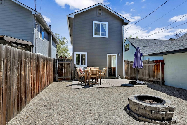 rear view of house featuring an outdoor fire pit, a fenced backyard, and a patio