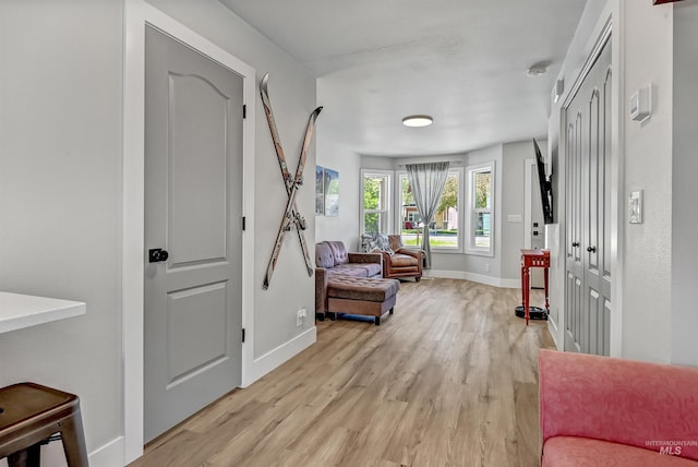 living area featuring light wood finished floors and baseboards