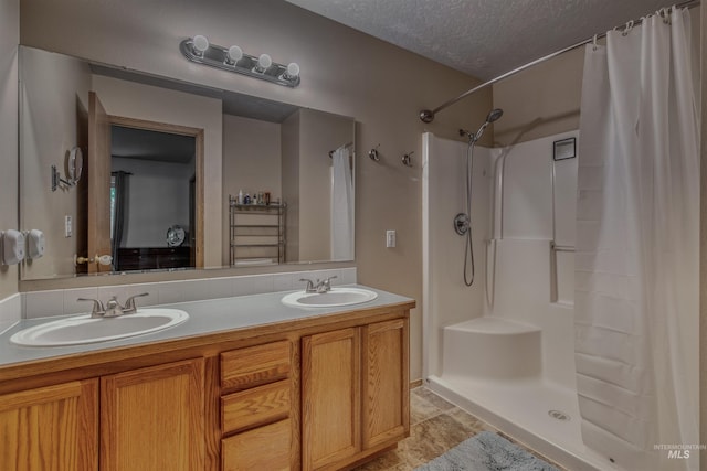 2209 S Plateau Dr, Nampa, ID 83686 - bathroom featuring double vanity, a shower with curtain, and a textured ceiling