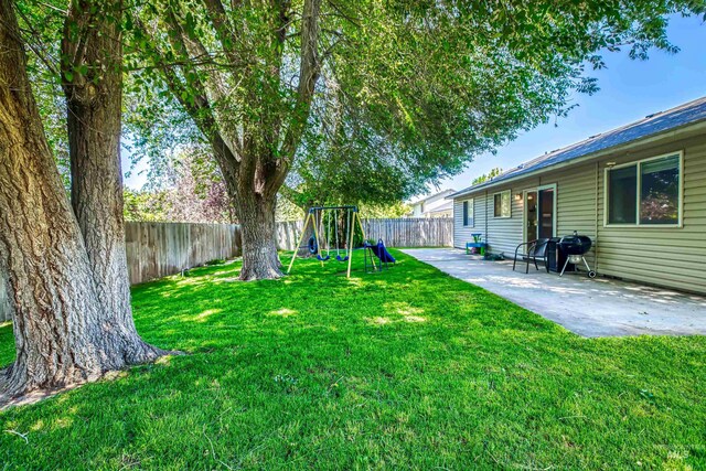 2209 S Plateau Dr, Nampa, ID 83686 - fenced backyard featuring a playground and a patio
