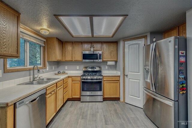 2209 S Plateau Dr, Nampa, ID 83686 - kitchen with appliances with stainless steel finishes, light wood-type flooring, a textured ceiling, and light countertops