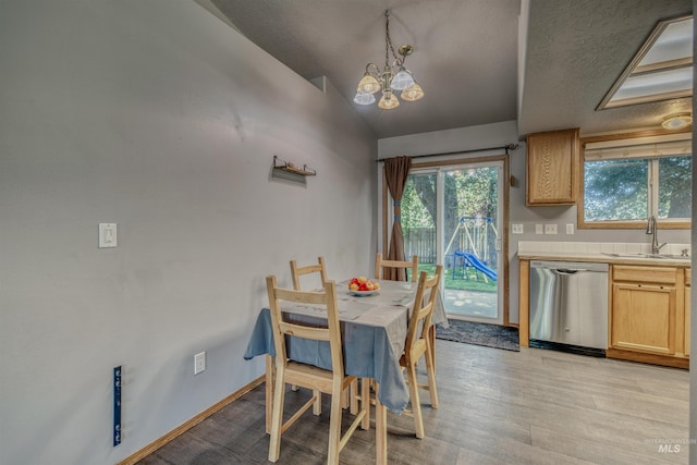 2209 S Plateau Dr, Nampa, ID 83686 - dining space with a chandelier, light wood-style flooring, vaulted ceiling, and a textured ceiling