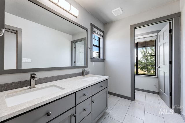 8315 Elk Ridge Ln, Middleton, ID 83644 - full bathroom with double vanity, plenty of natural light, baseboards, and tile patterned floors