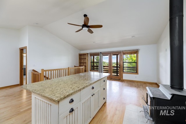 8315 Elk Ridge Ln, Middleton, ID 83644 - kitchen featuring ceiling fan, lofted ceiling, light wood-style floors, white cabinets, and a center island