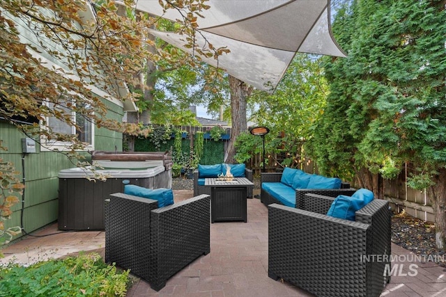 view of patio / terrace with a hot tub, an outdoor hangout area, and a fenced backyard