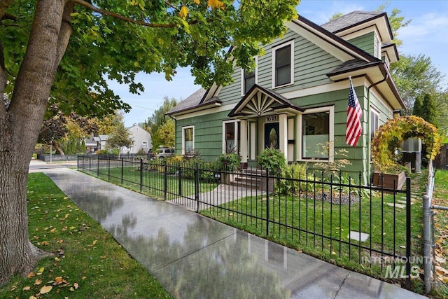 view of front facade with a fenced front yard and a front lawn