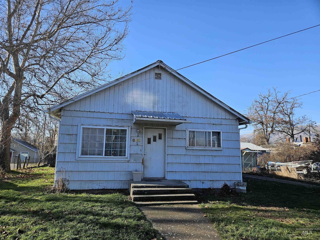 bungalow-style home with a front yard