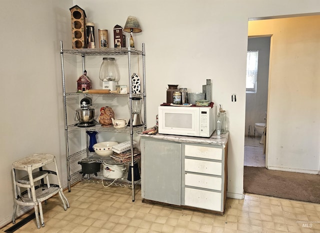 606 24th St, Lewiston, ID 83501 - bar area featuring white microwave, light flooring, and baseboards