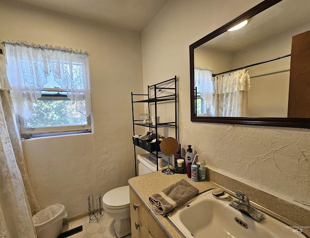 606 24th St, Lewiston, ID 83501 - bathroom featuring toilet, vanity, a textured wall, baseboards, and a shower with curtain