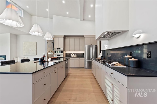 kitchen with dark countertops, a large island, stainless steel appliances, and premium range hood