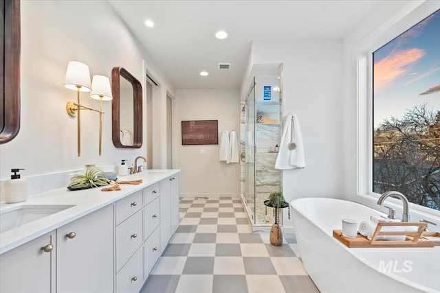 bathroom with double vanity, visible vents, a sink, a shower stall, and tile patterned floors