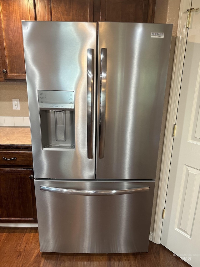 details with stainless steel fridge and dark hardwood / wood-style flooring