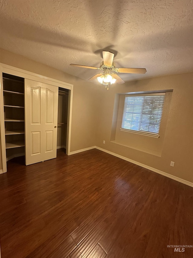 unfurnished bedroom featuring ceiling fan, dark hardwood / wood-style floors, a textured ceiling, and a closet