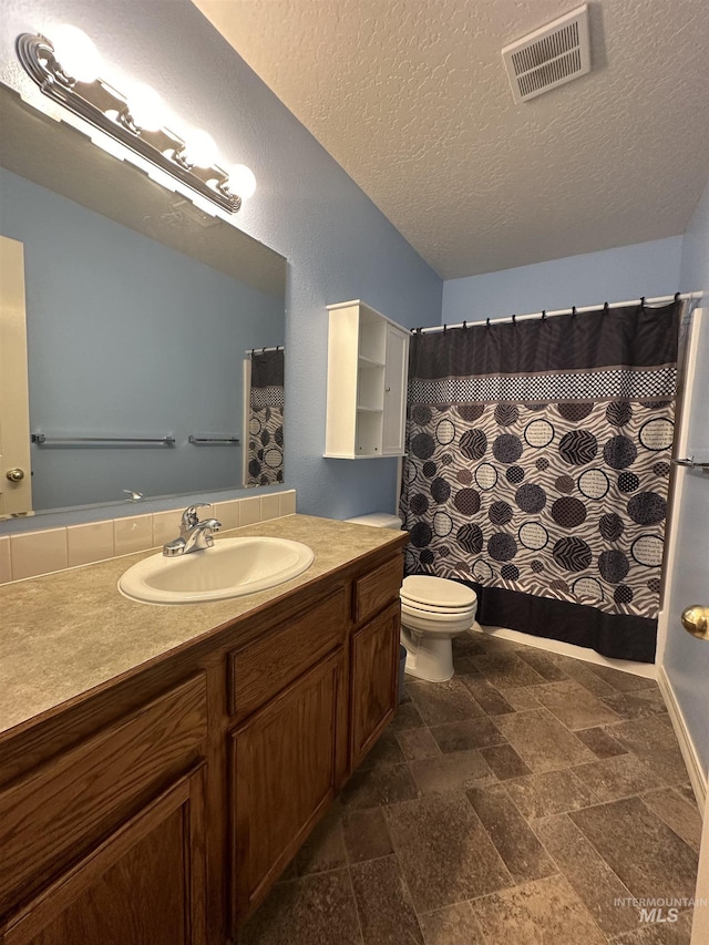 bathroom with vanity, a textured ceiling, and toilet