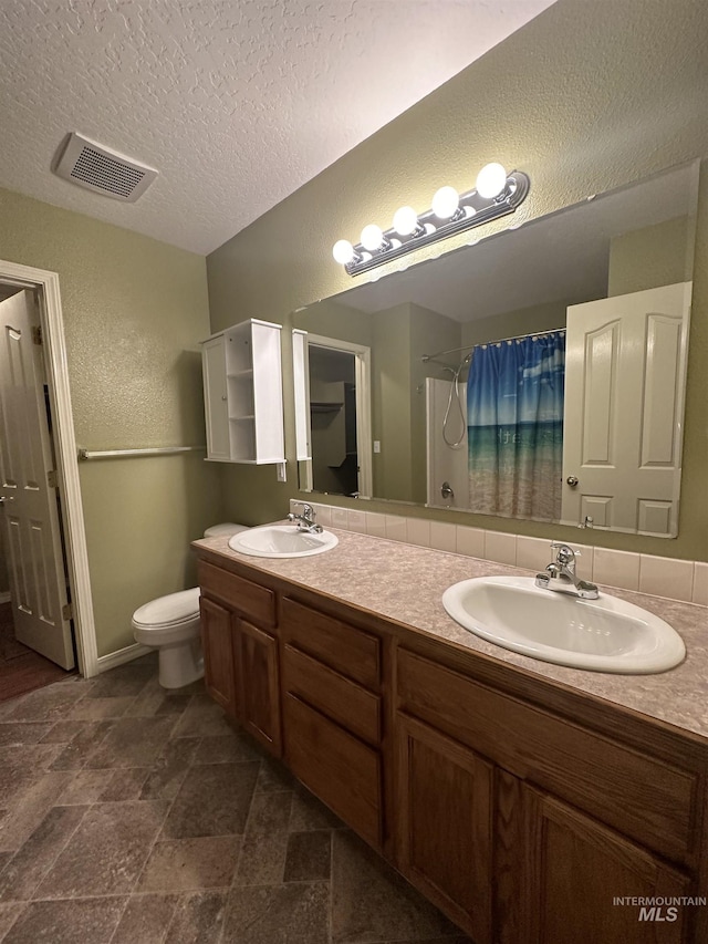 bathroom featuring vanity, a shower with shower curtain, a textured ceiling, and toilet