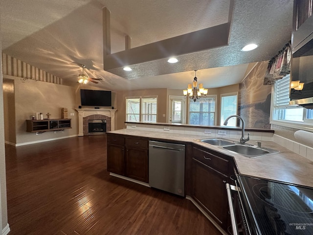 kitchen featuring sink, a tile fireplace, stainless steel appliances, dark hardwood / wood-style floors, and ceiling fan with notable chandelier