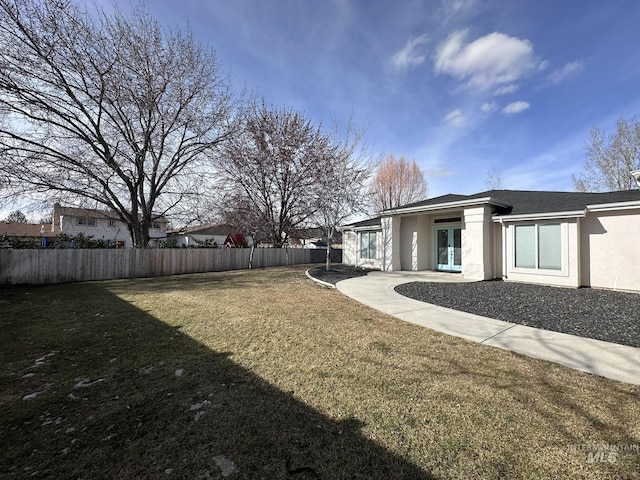 view of yard with fence and french doors