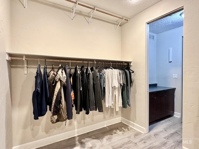 spacious closet with wood finished floors and visible vents