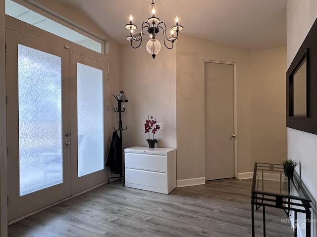 doorway with a chandelier, french doors, wood finished floors, and baseboards